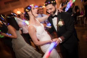 A summer wedding at Bourne Mansion is in full swing as the bride and groom share a magical dance, lighting up the night with glow sticks at their reception.