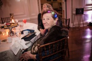 A woman sitting at a table with lights on her head at Bourne Mansion.