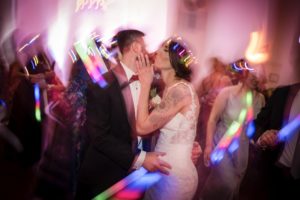 A summer wedding at Bourne Mansion, with a bride and groom sharing a romantic kiss on the dance floor.