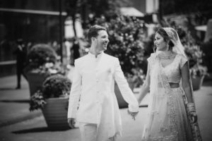 Wedding photo of a bride and groom walking down the street near Gotham Hall.