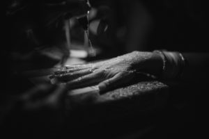 Black and white photo of henna on a woman's hand captured at a wedding.