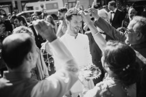 Black and white photo of a man throwing his hand up in the air at Gotham Hall wedding.