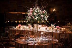 A Wedding reception at Gotham Hall with flowers and candles adorning the table.