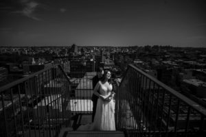 A wedding couple standing on a balcony overlooking the city at 501 Union in Brooklyn.