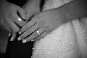 A black and white photo of a bride's hands holding a wedding ring at 501 Union in Brooklyn.