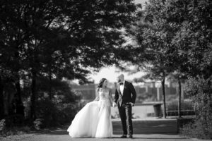 Black and white wedding photo of a bride and groom walking down a path at 74 Wythe.