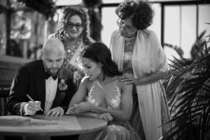 A bride and groom signing their wedding vows at the 74 Wythe venue.