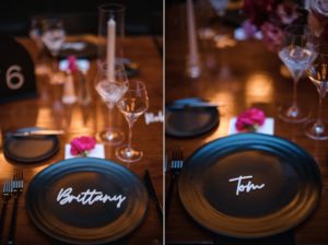 A wedding table setting at 501 Union in Brooklyn with black plates and flowers.