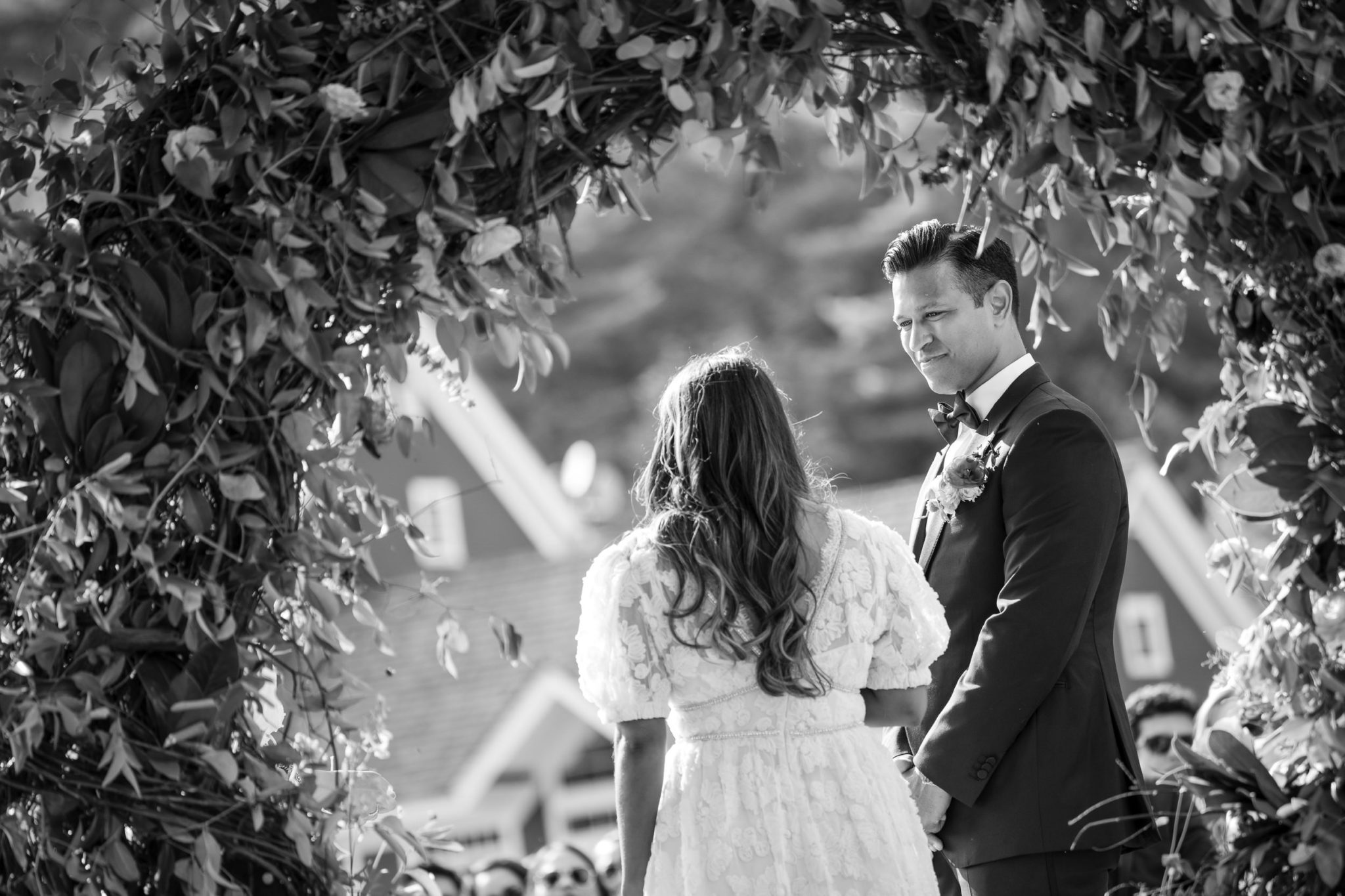 A bride and groom exchange loving gazes during their summer wedding ceremony at Riverside Farm
