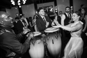 A Brooklyn bride and groom playing a conga drum at their wedding party at 501 Union.