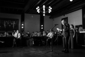 A black and white photo of a man giving a speech at a Brooklyn wedding.