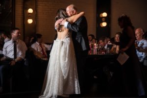 A bride and groom hugging during their first dance at their wedding in Brooklyn.