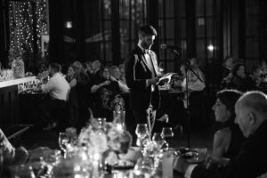 A man is giving a speech at a Brooklyn wedding reception.