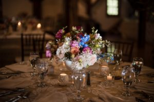 A beautiful arrangement of summer flowers on a table at a Riverside Farm wedding reception.