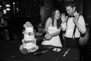 A Brooklyn wedding capture of the bride and groom cutting a cake in a black and white photo at 501 Union.