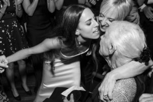 A woman is hugging an older woman at a wedding in New York.
