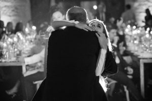A man and woman hugging at a wedding reception in New York.