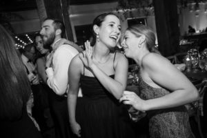Two women laughing at a wedding reception in New York.