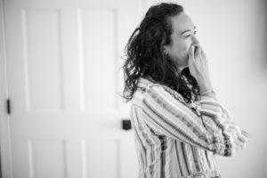 A woman is laughing while standing in front of a door in New York.