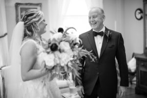 A black and white photo capturing the heartfelt moment between a bride and her father at their New York wedding.