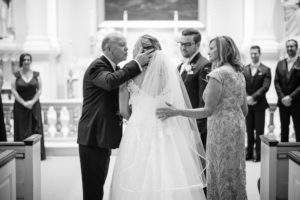 A bride's father putting her veil on during her New York wedding ceremony.