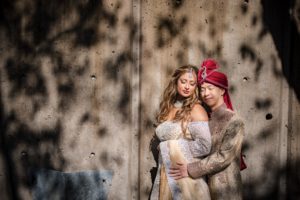 A New York wedding couple posing in front of a wall.