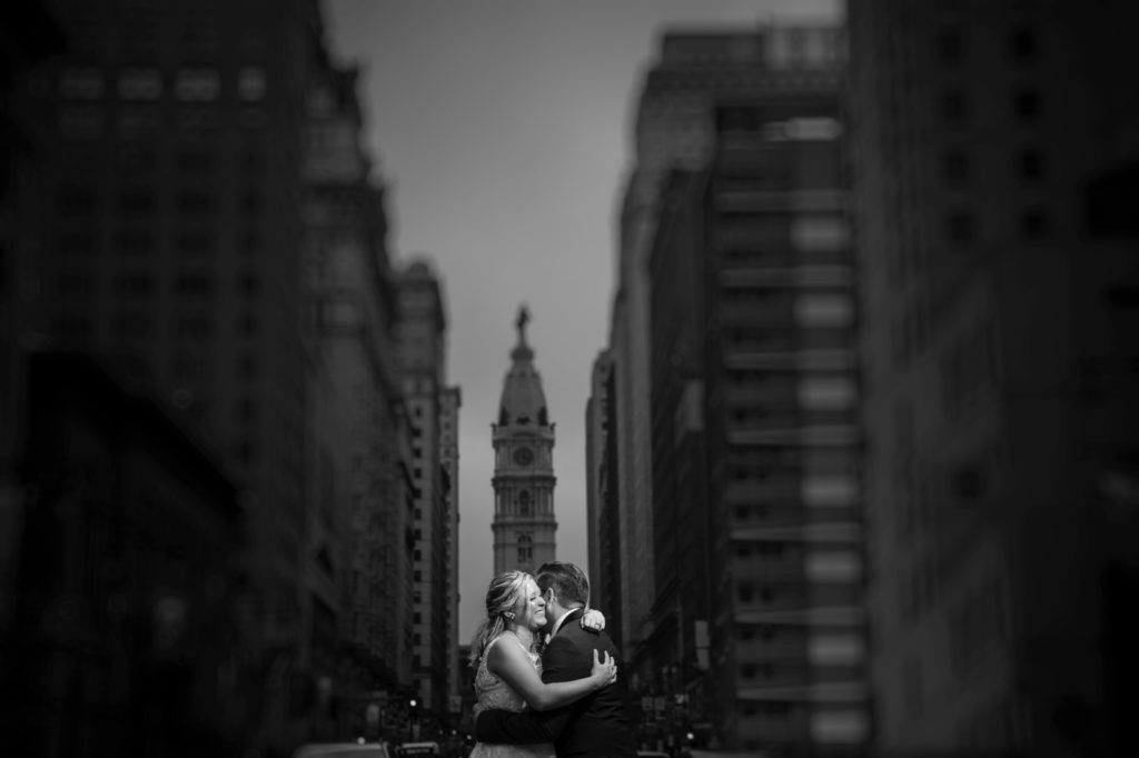 A wedding couple embraces in the middle of a bustling New York City street.