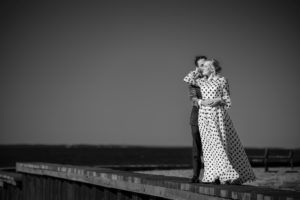 A couple in a polka dot dress standing on a dock in New York.