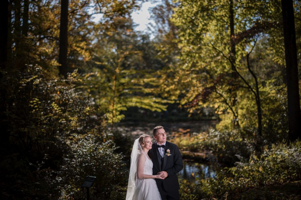 A wedding couple posing in front of a pond in New York.