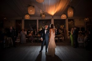 In the enchanting ambiance of a tent nestled amidst the vibrant cityscape of New York, a bride and groom share an intimate dance on their wedding night.