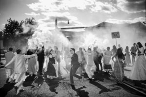 A black and white photo of a group of people at a wedding in New York, with smoke coming out of their hair.