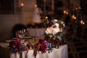 In the vibrant city of New York, an elegant wedding reception blooms with a beautifully adorned table featuring exquisite flowers and romantic candles.