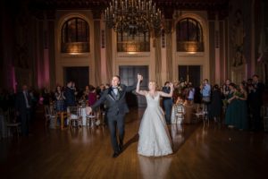 A bride and groom dance at their New York wedding in a large ballroom.