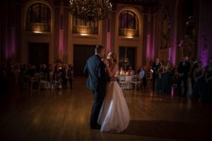 A bride and groom share their first dance in a large ballroom in New York City during their wedding.