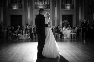 A newlywed couple dancing for the first time as wife and husband in a grand New York wedding venue.