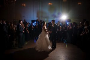 A wedding couple dance in front of a large group of people at their New York ceremony.