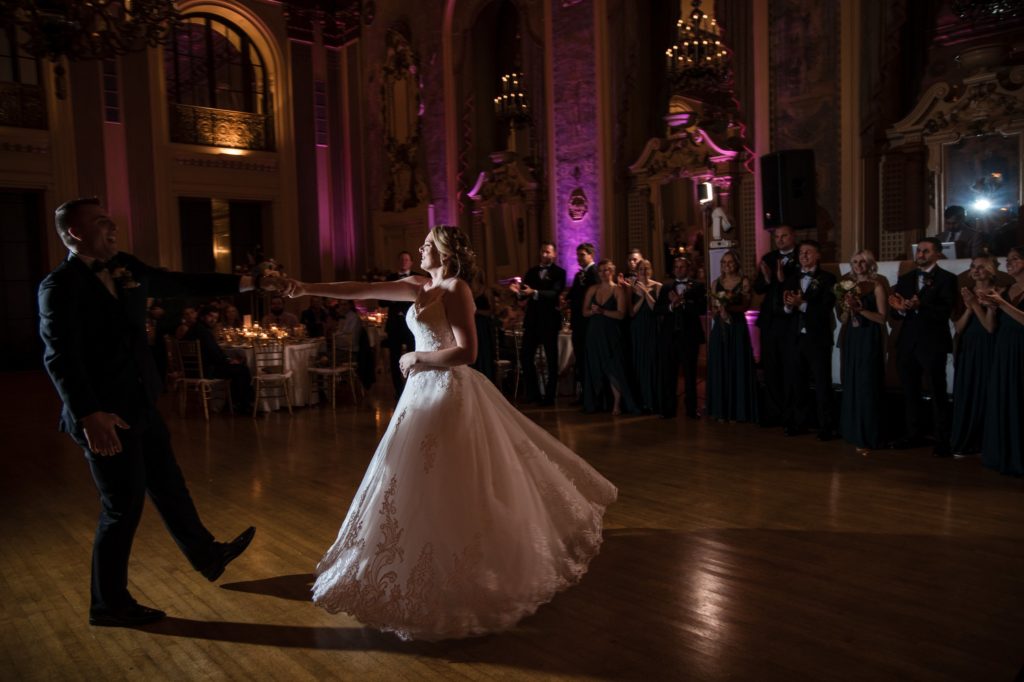 A bride and groom sharing their first dance in a lavish ballroom at their New York wedding.