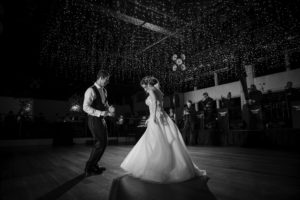 A bride and groom dance at their New York wedding in a black and white photo.