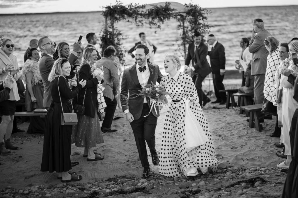 A bride and groom walk down the aisle at a beach wedding in New York
