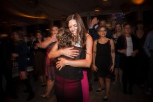 A woman hugging another woman at a wedding reception in New York.