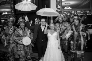 A bride and groom are holding umbrellas in a black and white photo from their New York wedding.