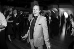 A man in a suit dancing on a wedding dance floor in New York.
