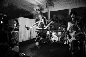 A black and white photo of a band performing on stage in New York.