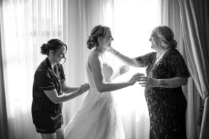 A woman in New York helps a bride into her wedding dress.
