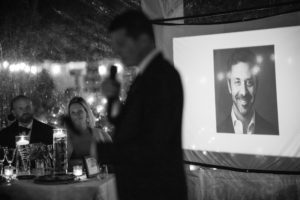 A man is giving a speech in front of a projection screen in New York.
