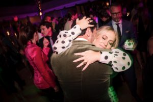 A man hugging a woman at a wedding party in New York.