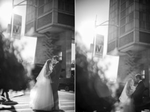 A New York bride and groom share a kiss in front of a building on their wedding day.