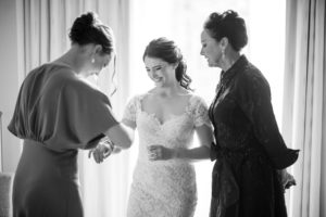 A bride is getting ready in a hotel room in New York with her bridesmaids for her wedding.