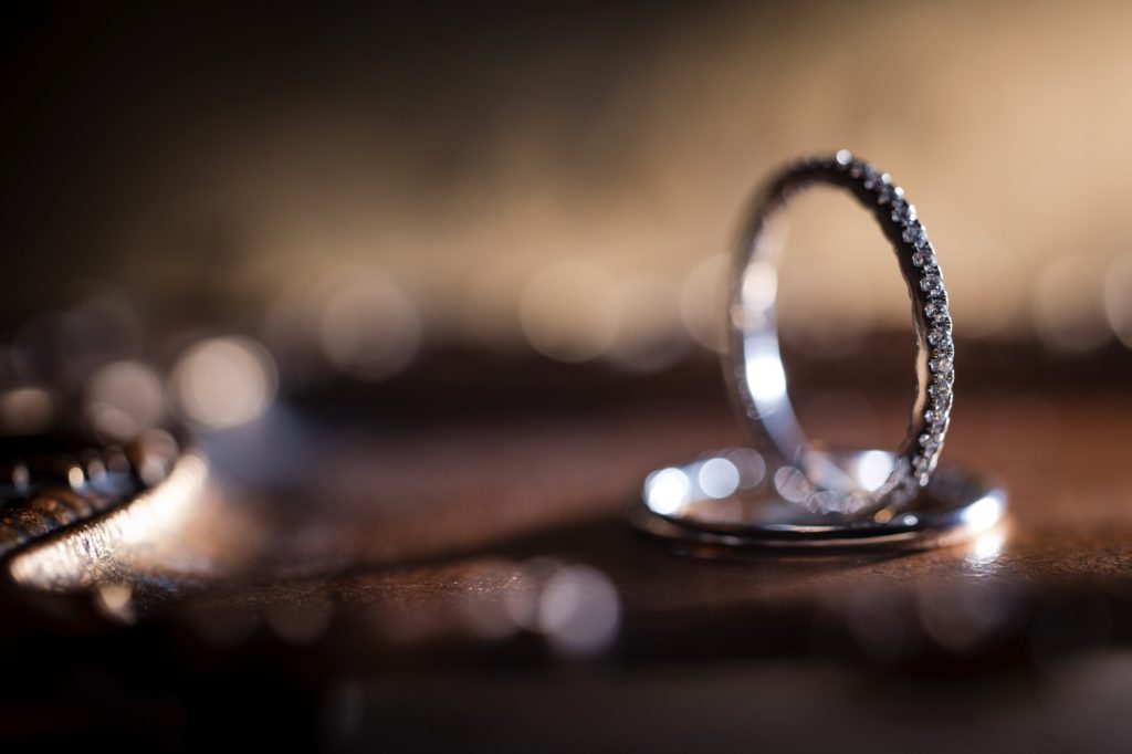 A wedding ring elegantly rests on a wooden table in New York.