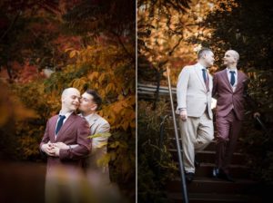 Two men in suits share a passionate kiss on the steps of a beautiful garden in New York.